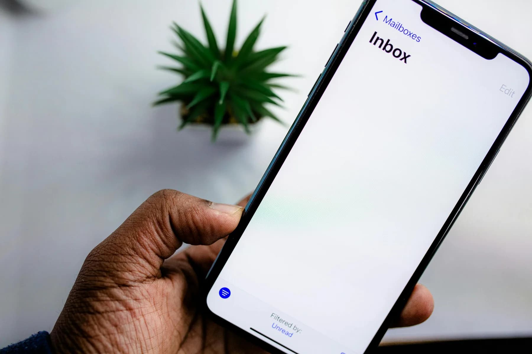Smartphone met een open mailbox in de hand.